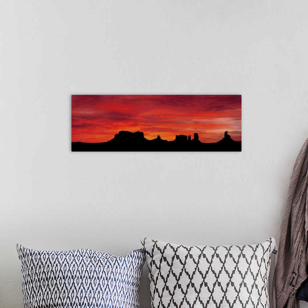 A bohemian room featuring Panoramic photograph of silhouettes of huge rock formations in the desert at sunset under a cloud...