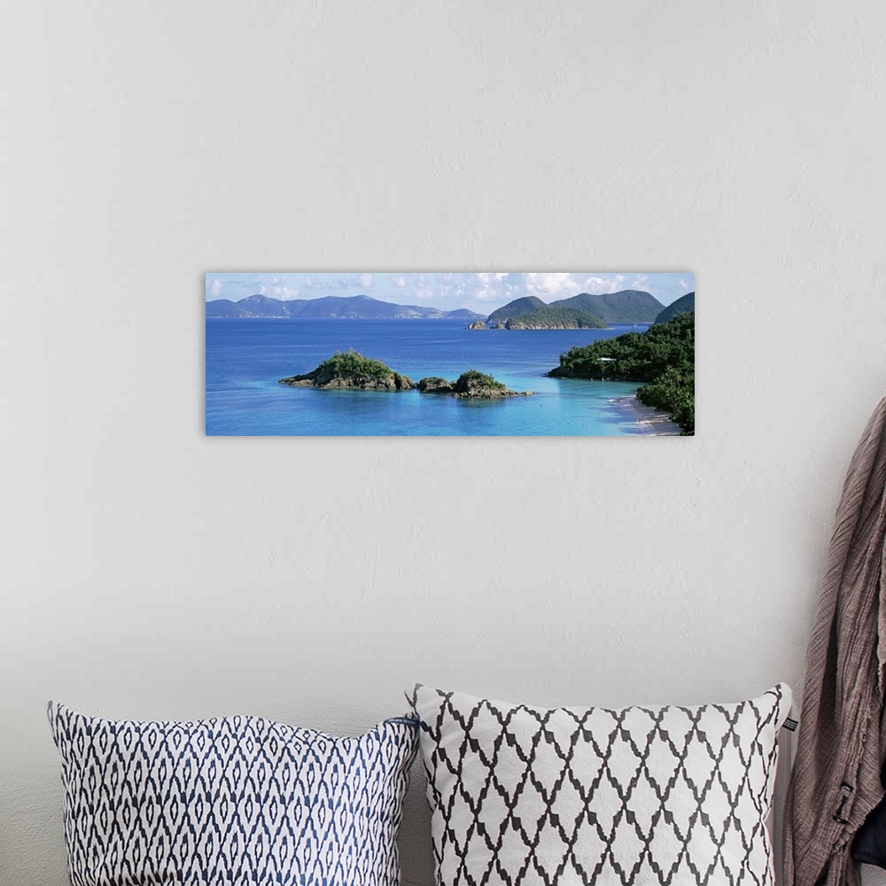 A bohemian room featuring This decorative wall is a panoramic landscape photograph of a small rocky island off the shore of...