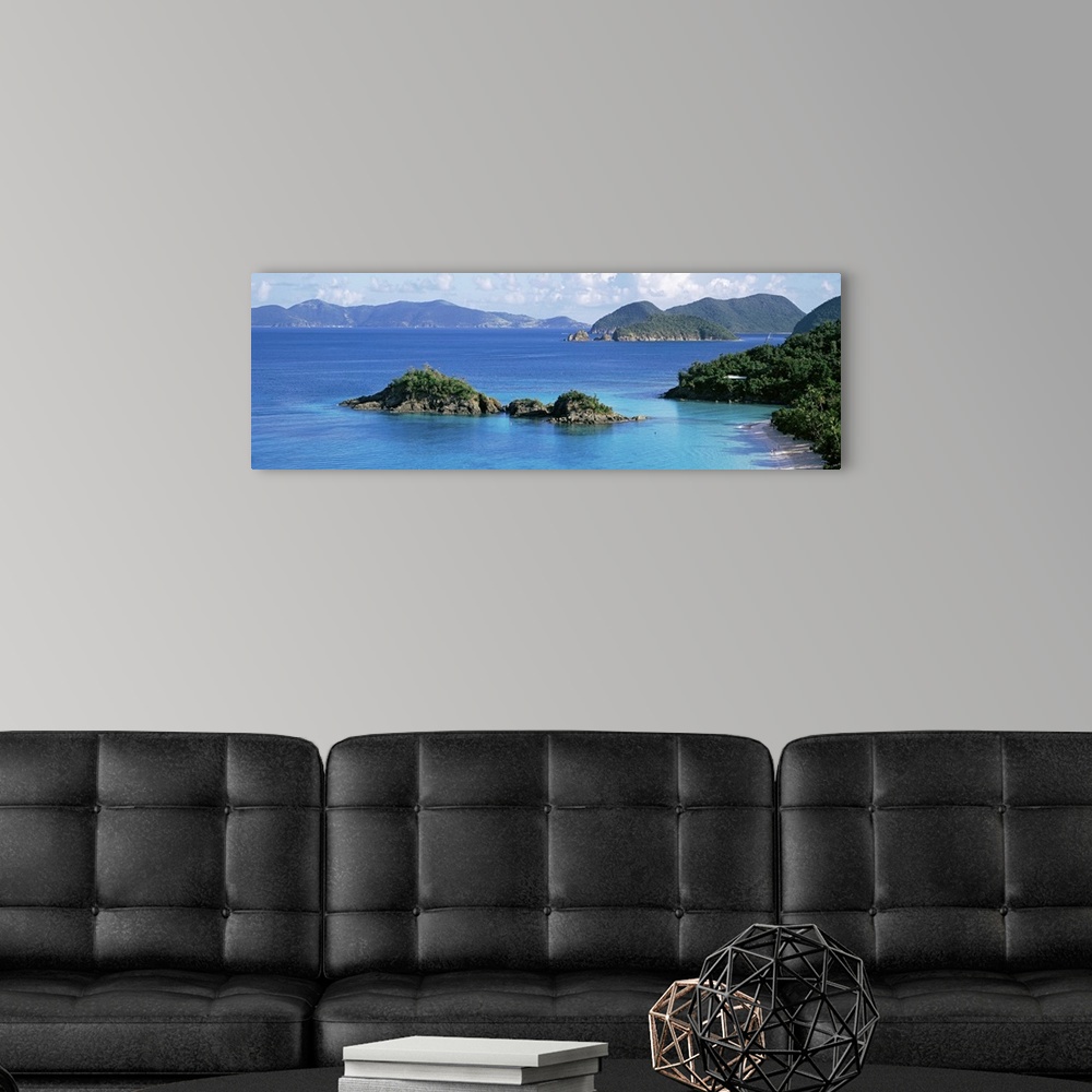 A modern room featuring This decorative wall is a panoramic landscape photograph of a small rocky island off the shore of...