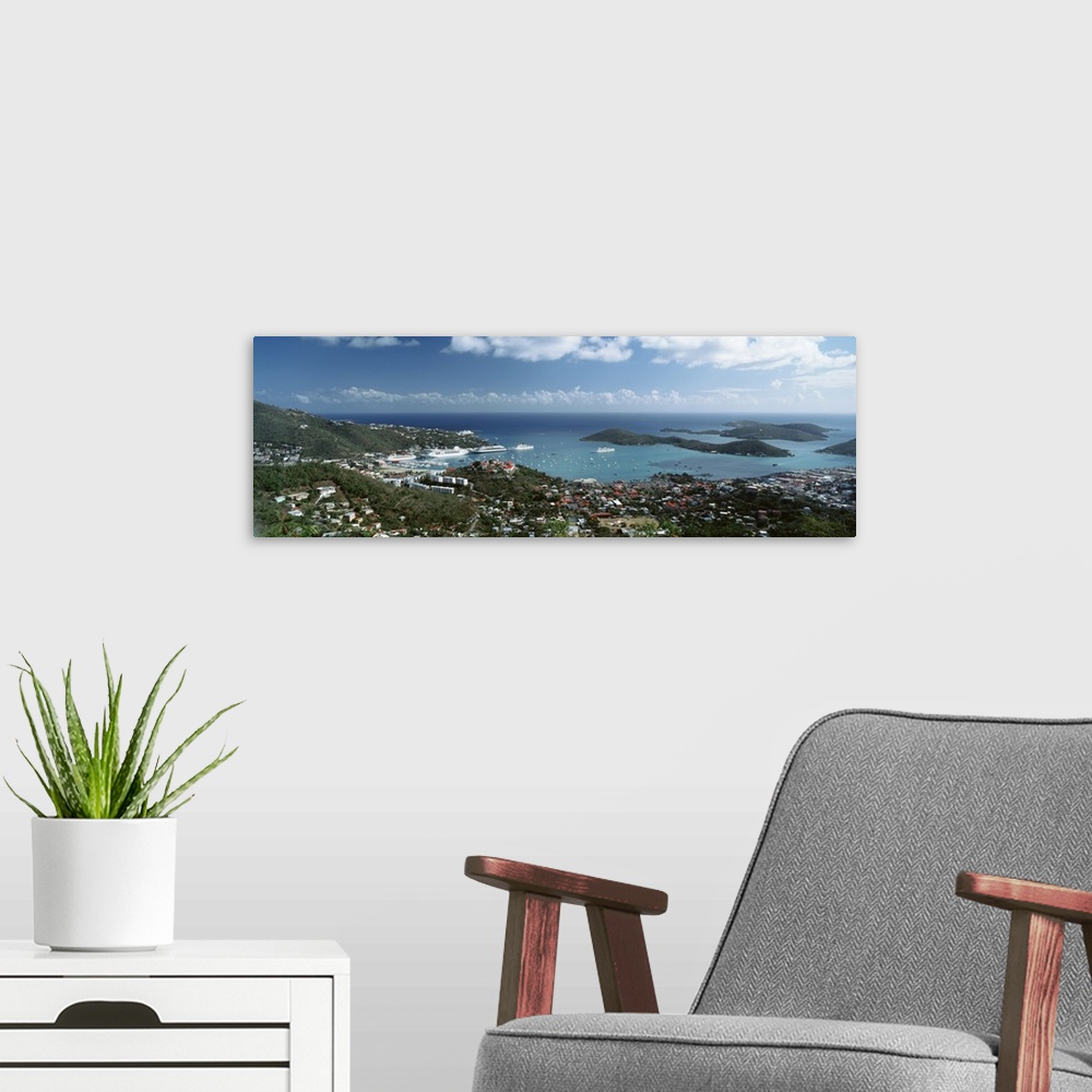 A modern room featuring Panoramic photograph of aerial view of city near water's edge under a cloudy sky.