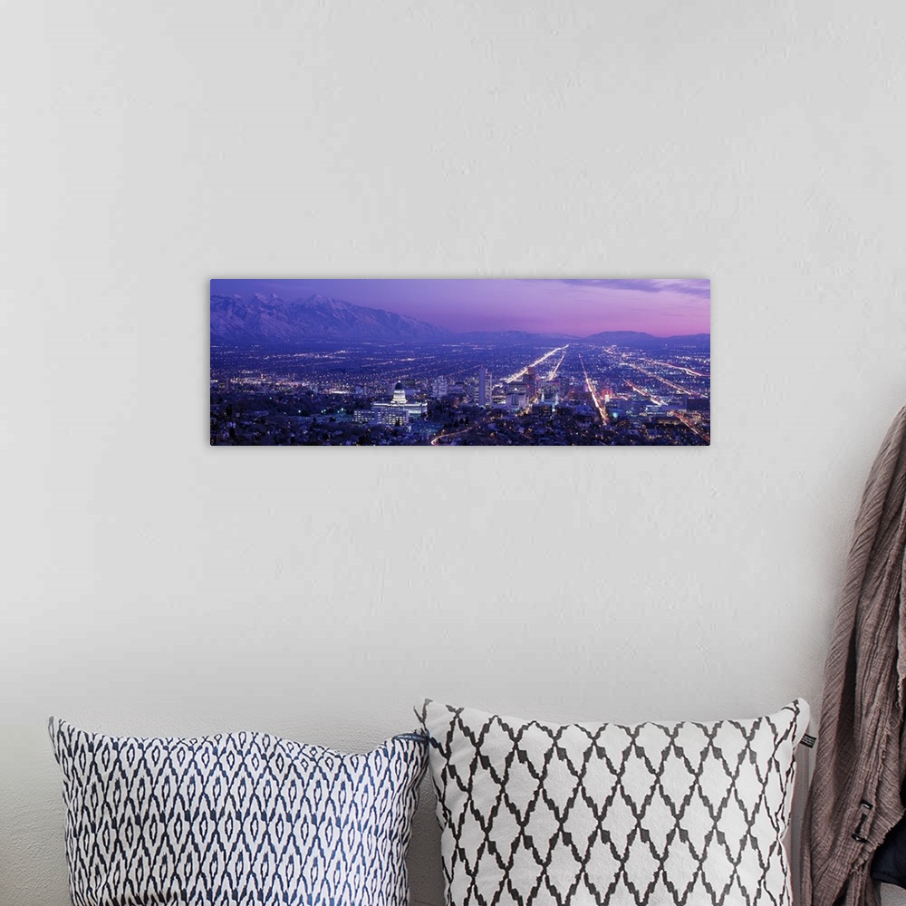 A bohemian room featuring High-angle panoramic photograph of city lit up at dusk with snow covered mountains in the distanc...