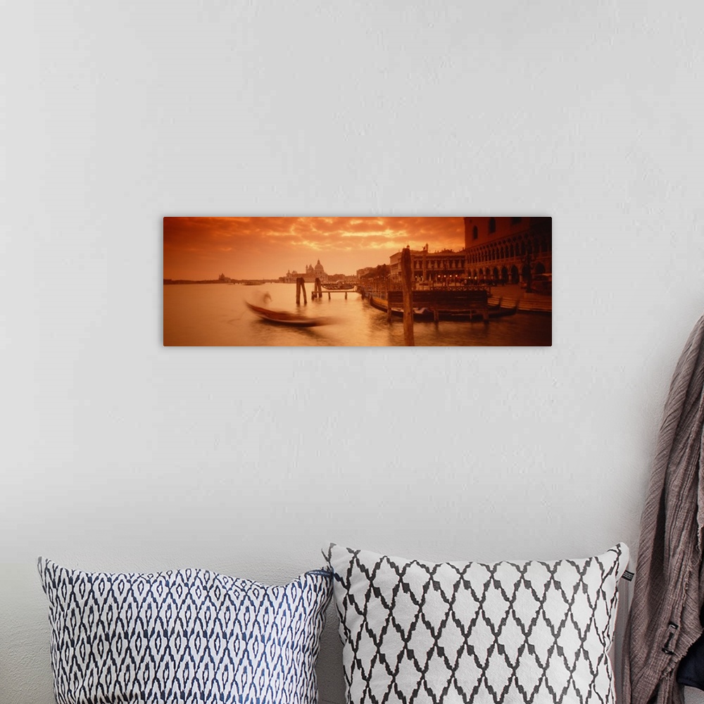 A bohemian room featuring Panorama of a small Italian harbor with a blurred gondola coming into port at sunset.