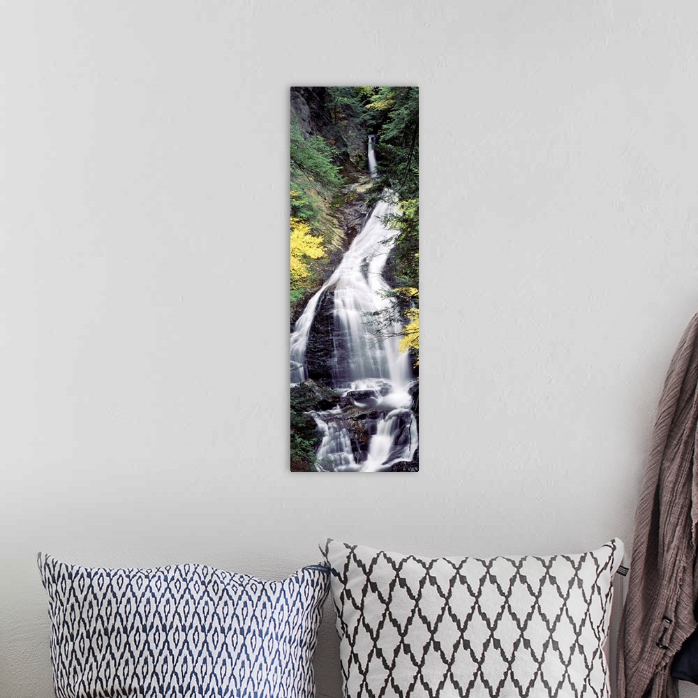 A bohemian room featuring Vertical, large photograph of Moss Glen Falls surrounded by rocky terrain and fall foliage, in th...