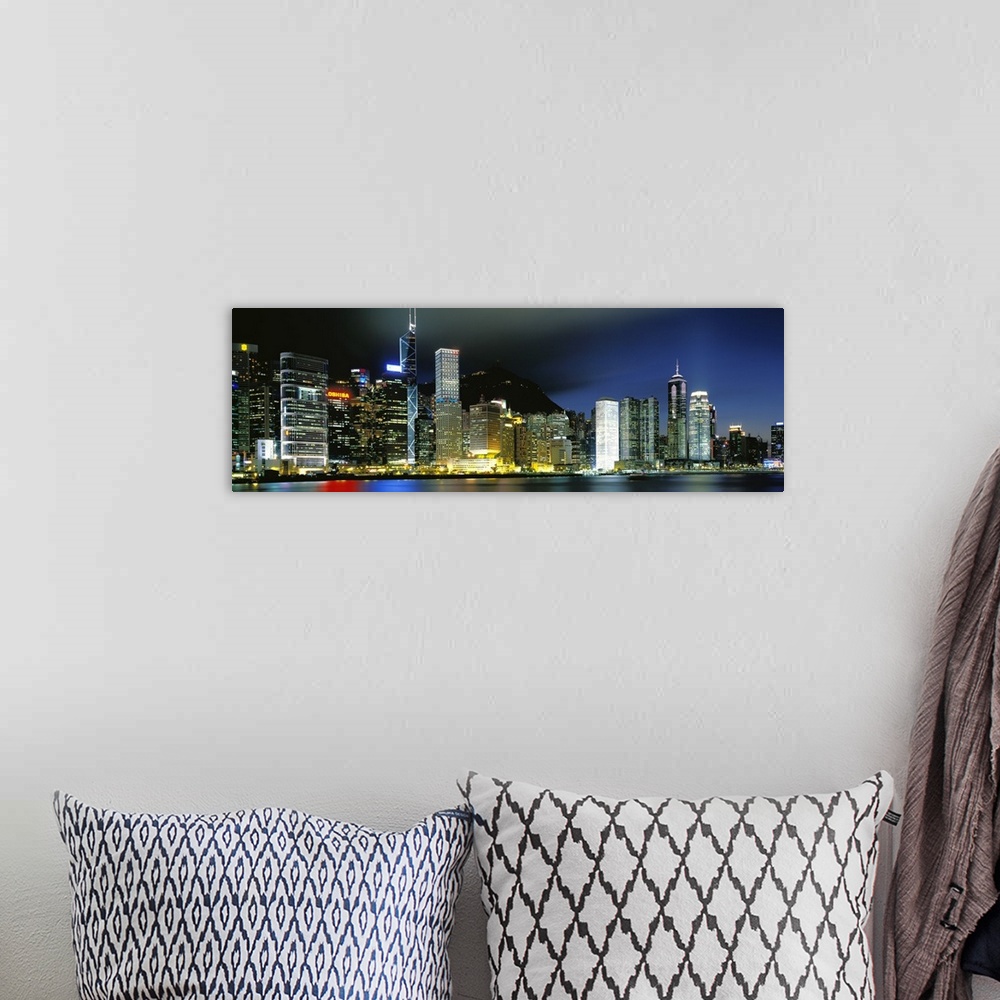 A bohemian room featuring Panoramic photograph of city skyline.  The buildings are lit up in the night sky and are reflecte...