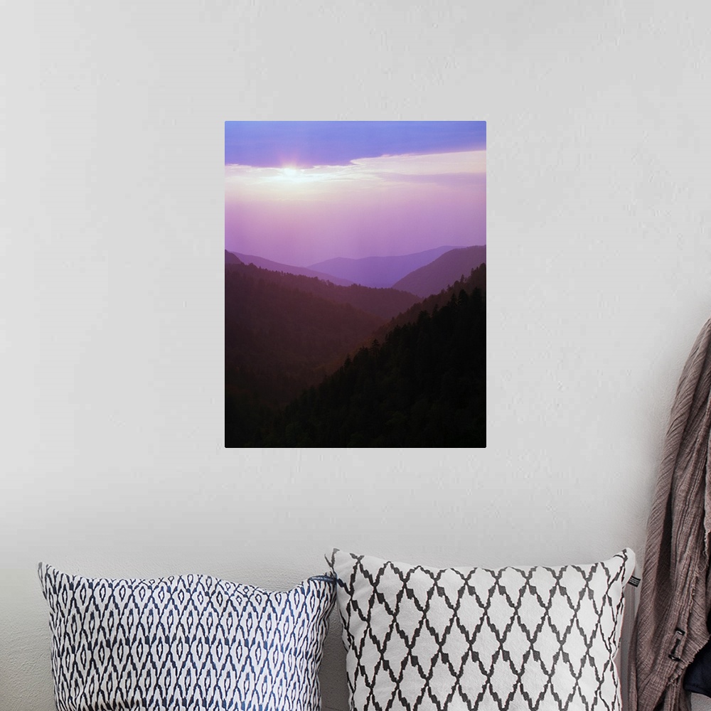 A bohemian room featuring Photograph of foggy mountain range under a cloudy sky with sun peeking through.