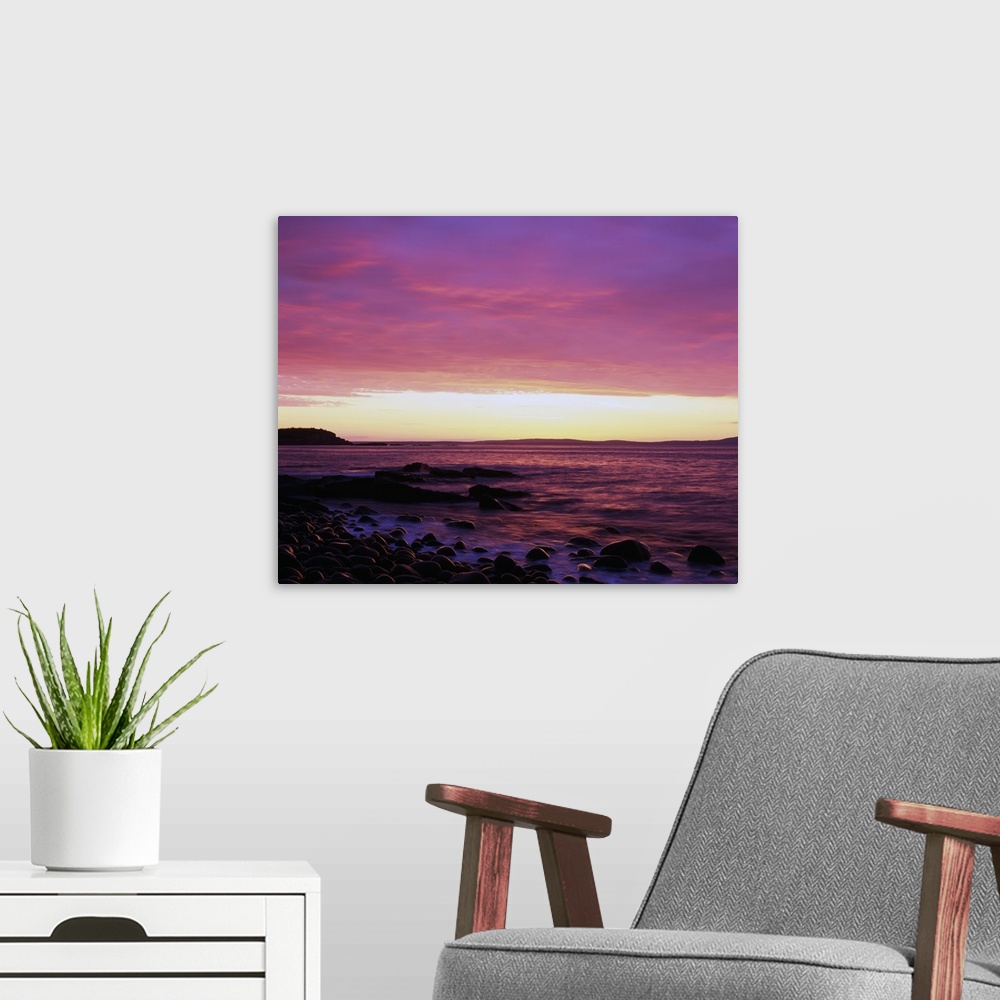 A modern room featuring This large piece is a picture taken of the sun rise off the coast of Maine. Rocks line the edge o...