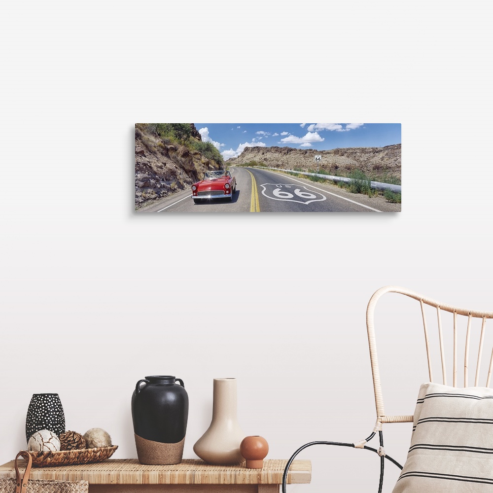 A farmhouse room featuring Panoramic photograph of classic car on highway winding through the mountains under a cloudy sky.