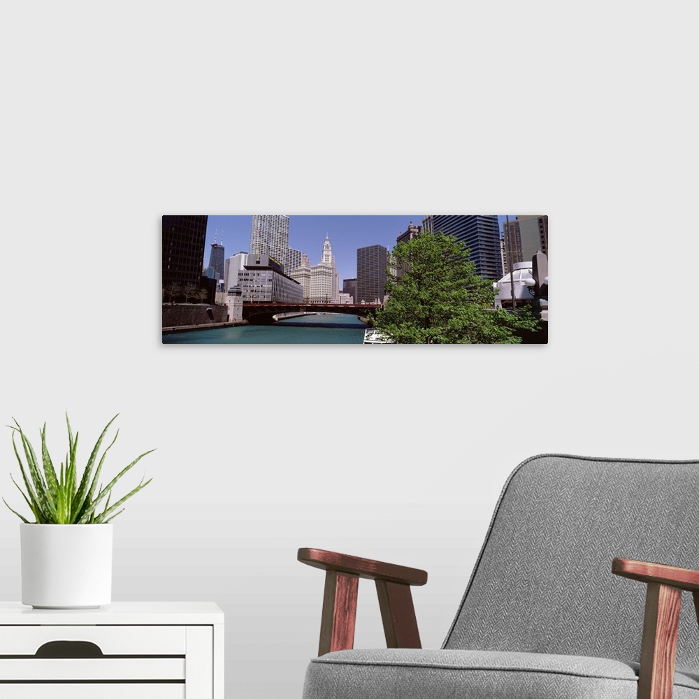 A modern room featuring Panoramic photograph of overpass with lake below and city buildings and skyscrapers in the backgr...