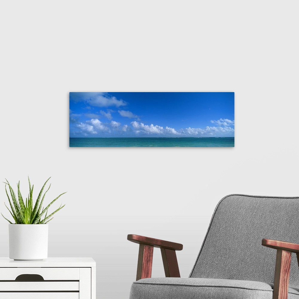 A modern room featuring Panoramic photograph of ocean under a cloudy sky.