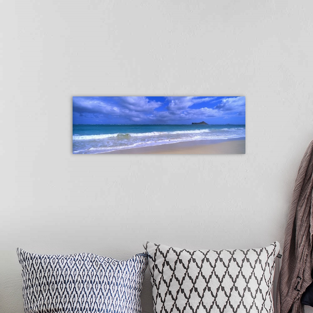 A bohemian room featuring Panoramic photograph of waves breaking on the beach during a cloudy day with island in the distan...