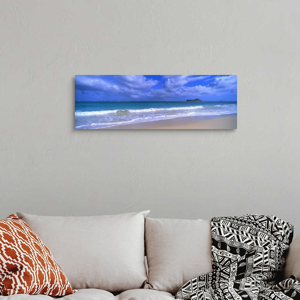A bohemian room featuring Panoramic photograph of waves breaking on the beach during a cloudy day with island in the distan...
