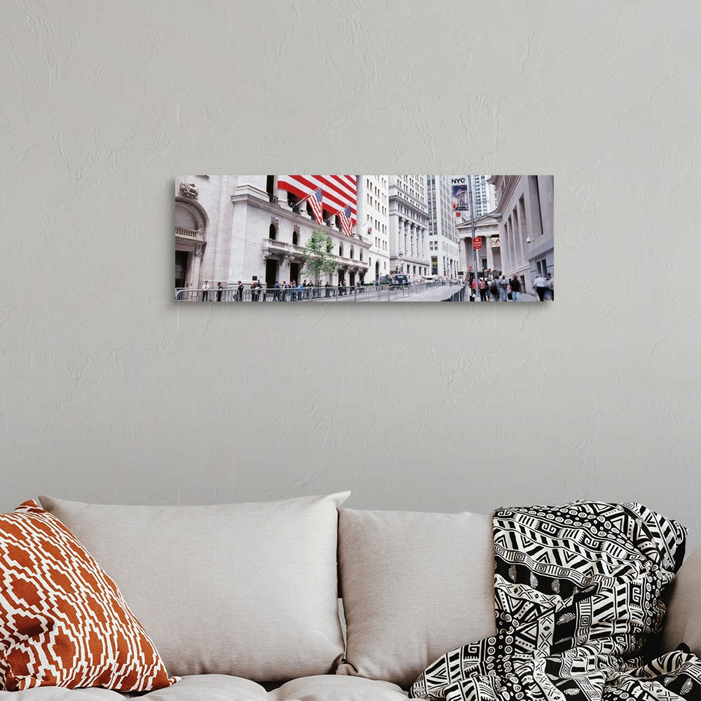 A bohemian room featuring Large panoramic photograph of wall street in NYC with people walking on the sidewalk and a large ...