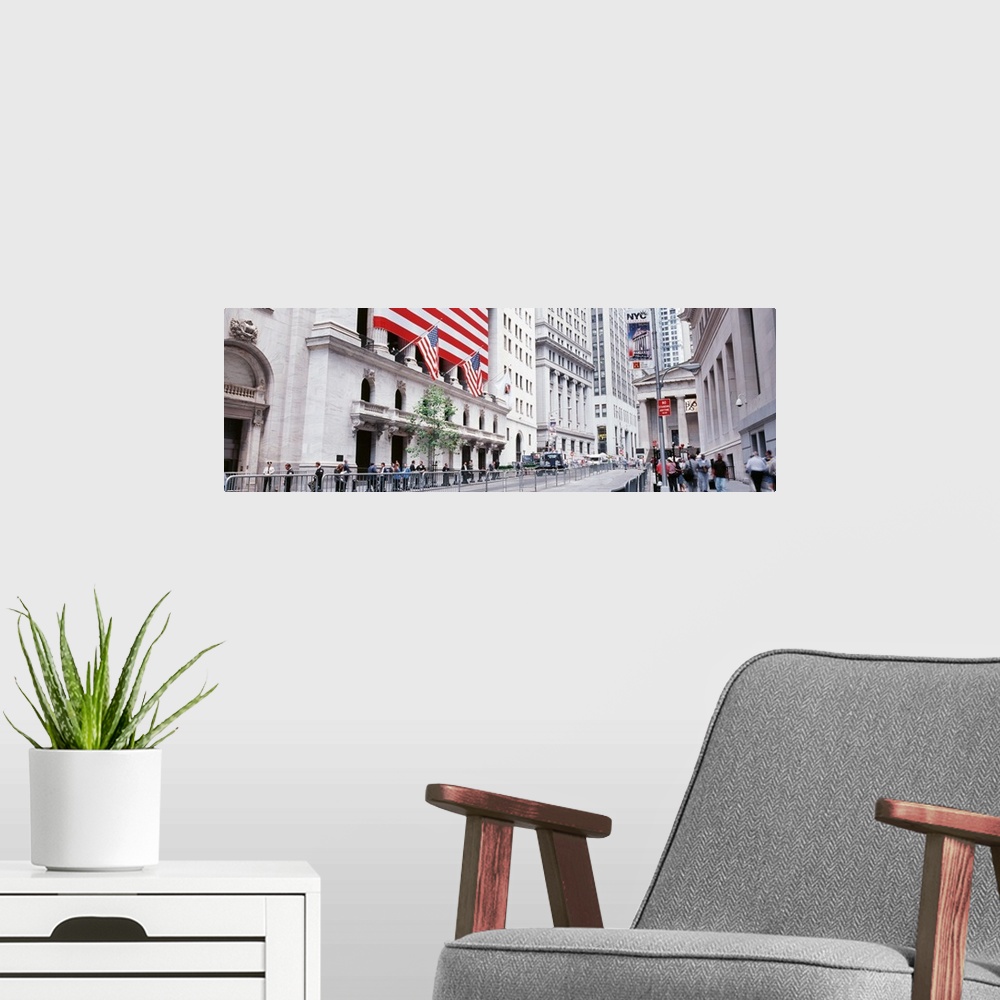 A modern room featuring Large panoramic photograph of wall street in NYC with people walking on the sidewalk and a large ...