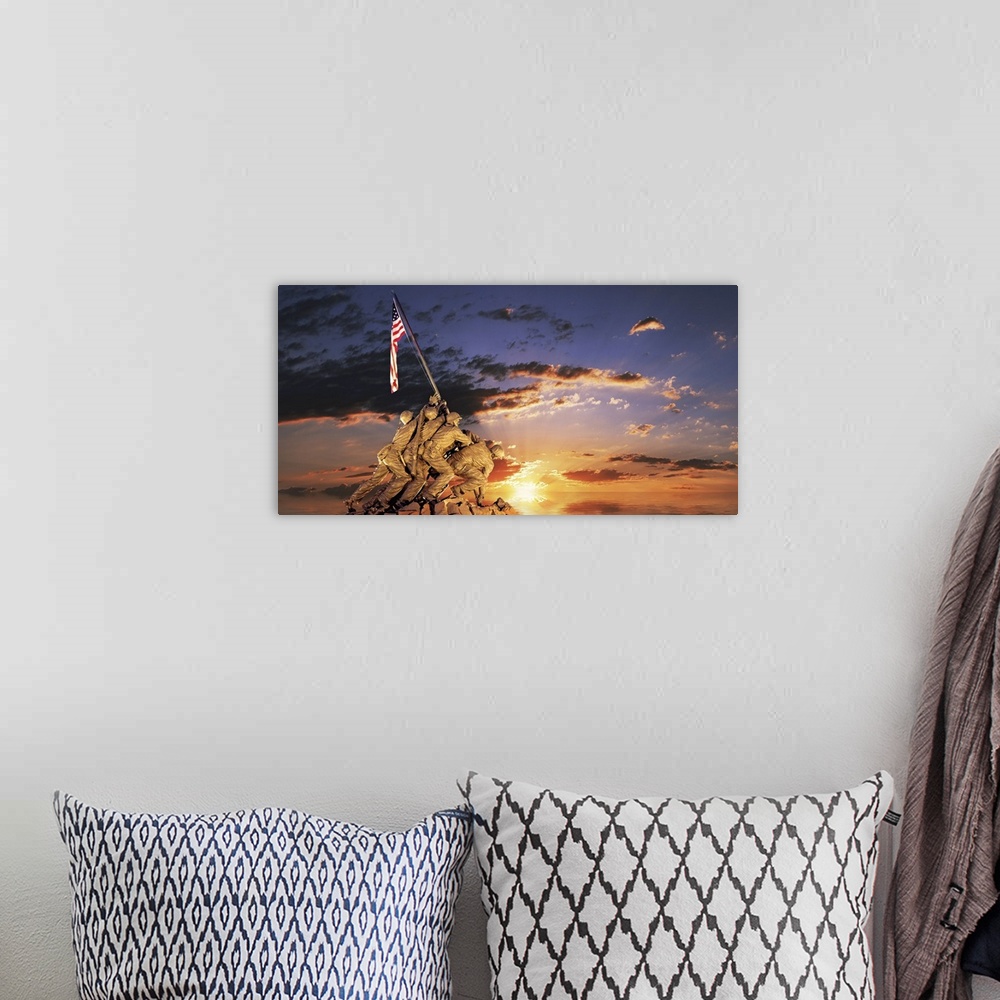 A bohemian room featuring Composite image of a statue of American soldiers raising a flag on a rocky mount and the sun sett...