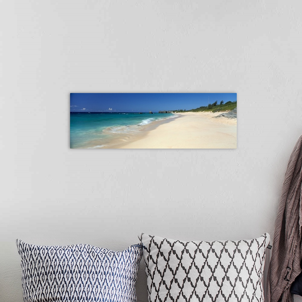 A bohemian room featuring Ocean waves wash up on a sandy tropical shore in this panoramic seascape photographed on a sunny ...