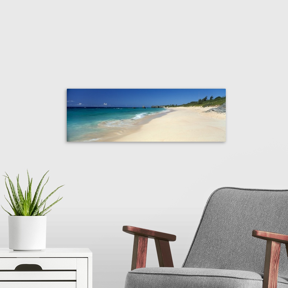 A modern room featuring Ocean waves wash up on a sandy tropical shore in this panoramic seascape photographed on a sunny ...