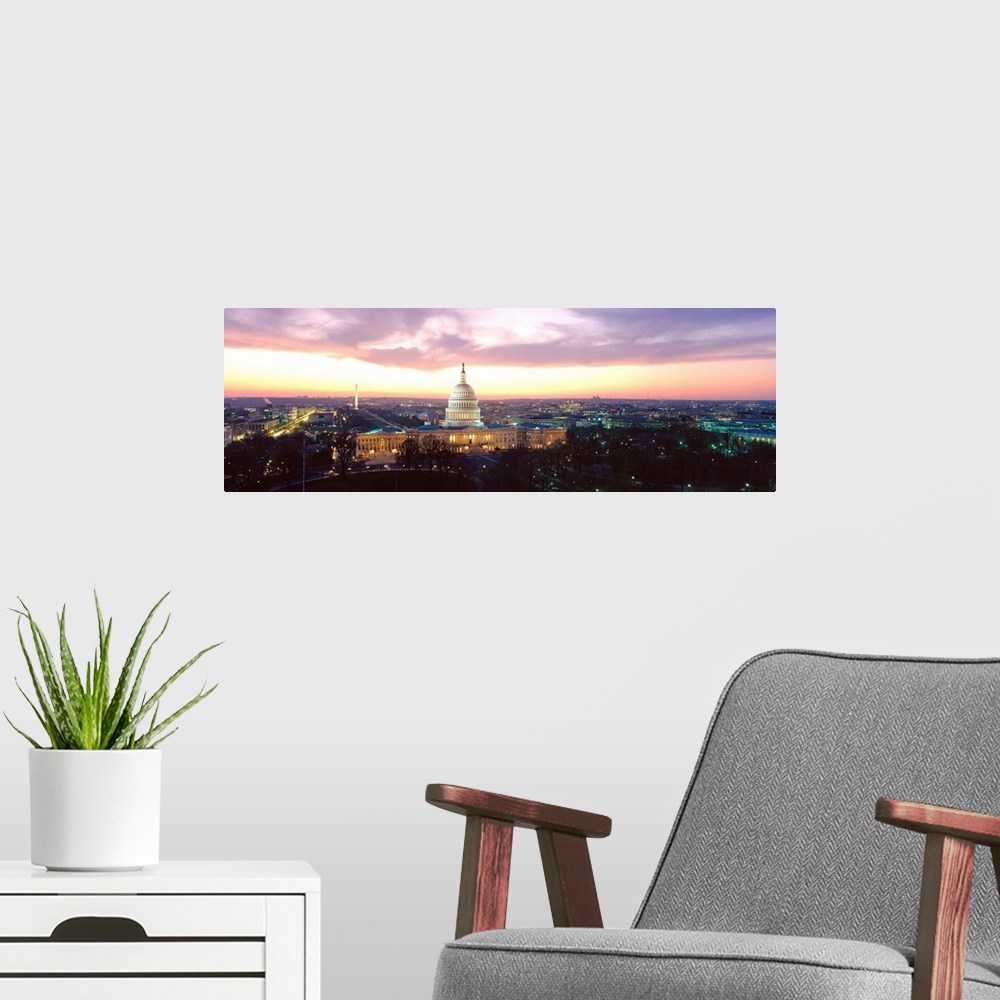 A modern room featuring A high angle photograph of the Capital Building and National Mall illuminated in the evening light.