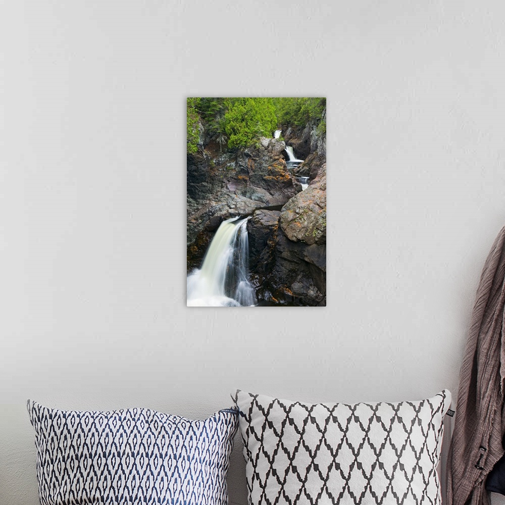 A bohemian room featuring This vertical nature photograph shows a rocky mountain face covered with trees and a river cuts t...