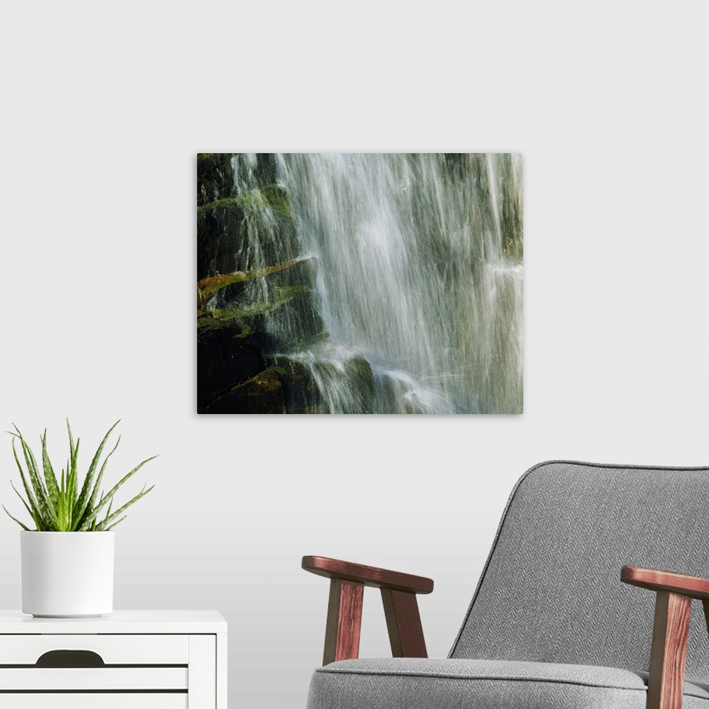 A modern room featuring Water falling over rocks, detail.