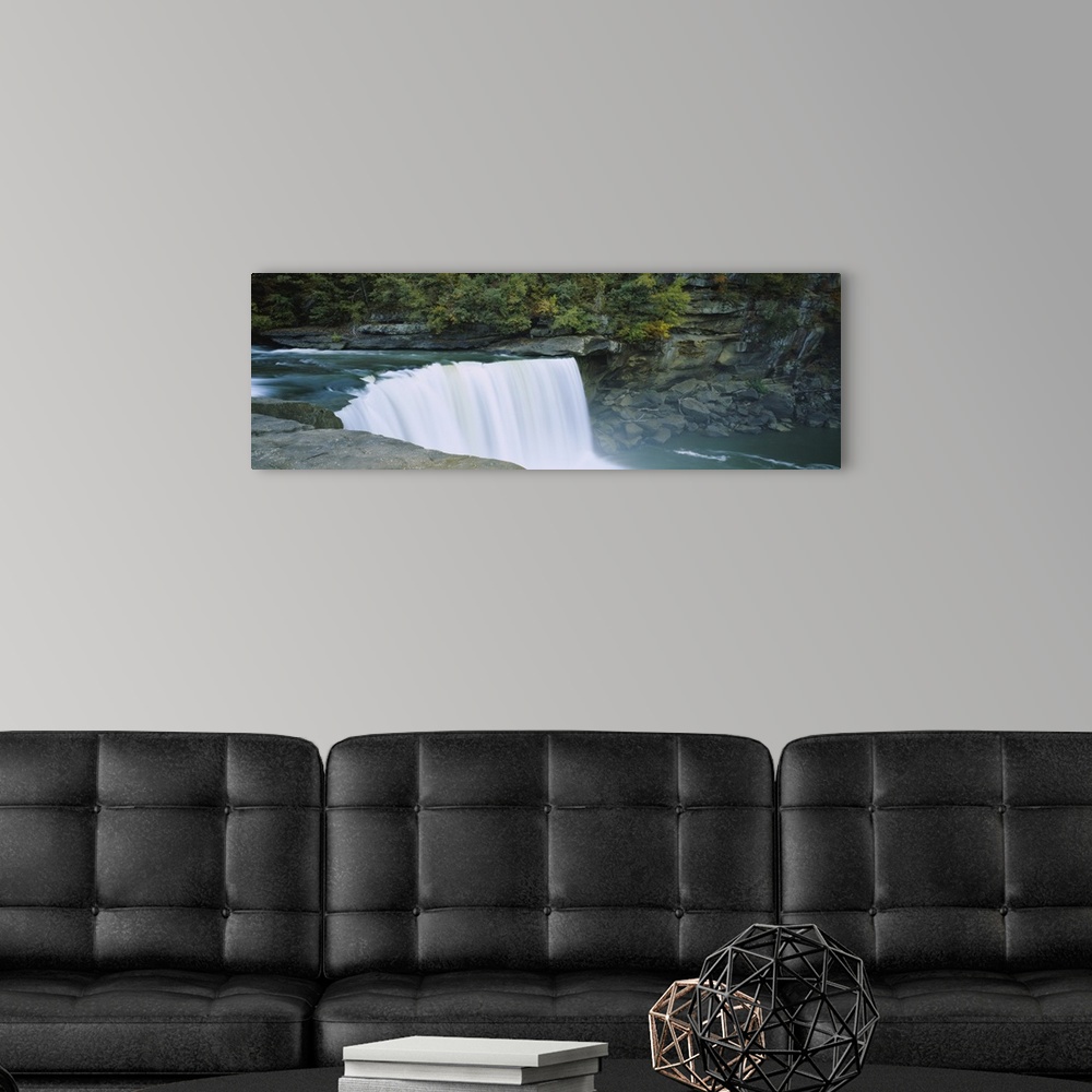 A modern room featuring Wall docor of a wide waterfall off of a rocky cliff flowing into a pool of water.