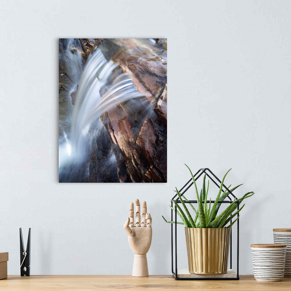 A bohemian room featuring This photograph is taken from the top of a waterfall as it rushes down over a rocky cliff.