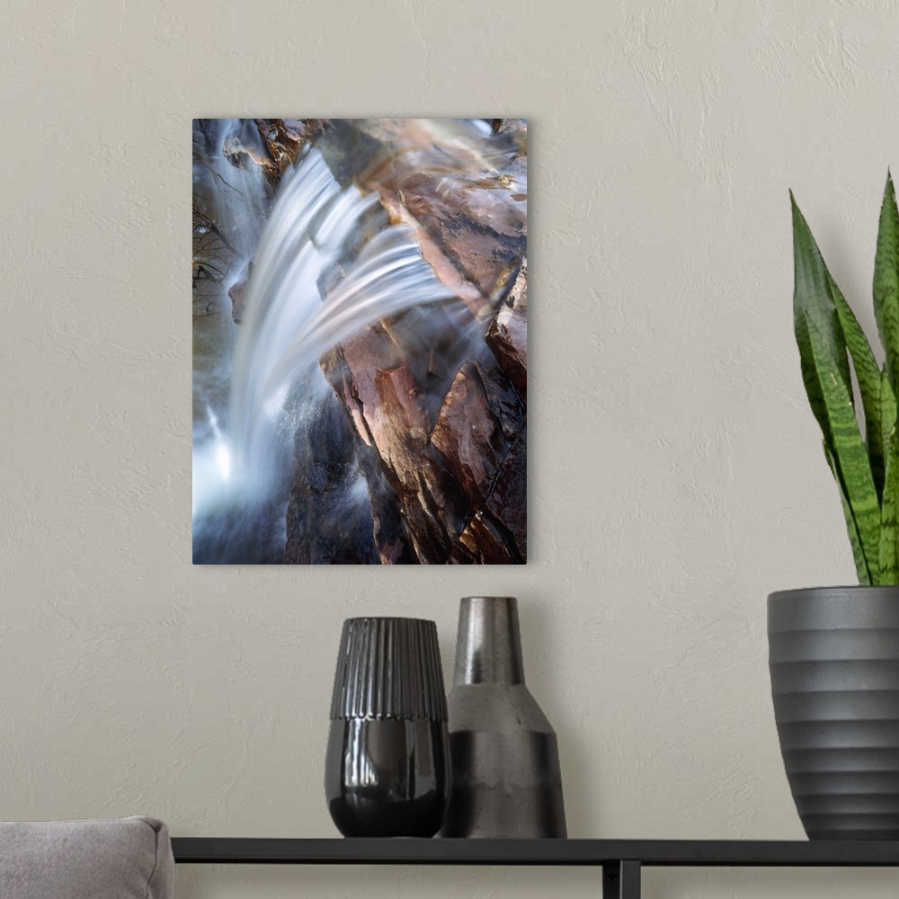 A modern room featuring This photograph is taken from the top of a waterfall as it rushes down over a rocky cliff.