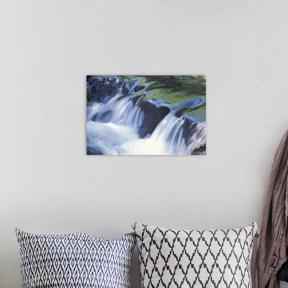 A bohemian room featuring Up-close photograph of water flowing over huge rocks.
