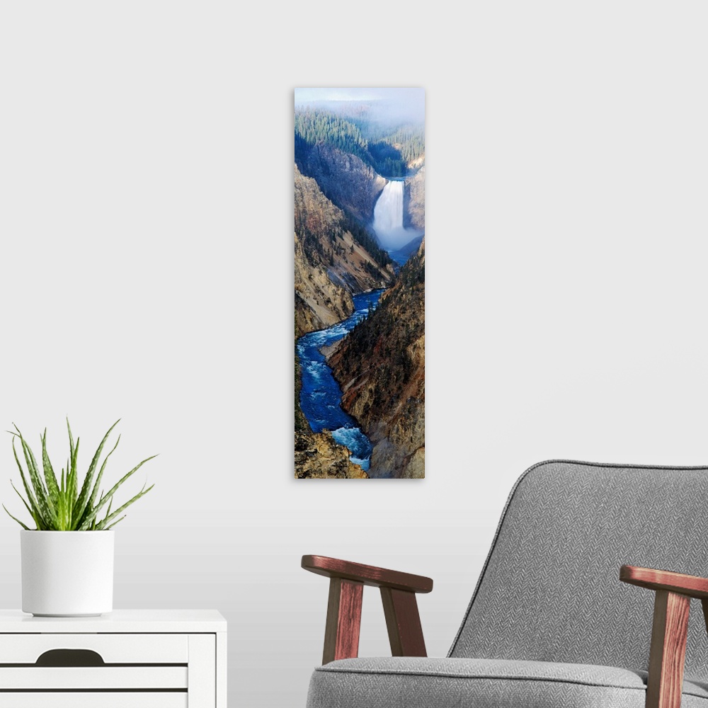 A modern room featuring Giant panoramic artwork of a waterfall dumping water into a small river at the bottom of a canyon...