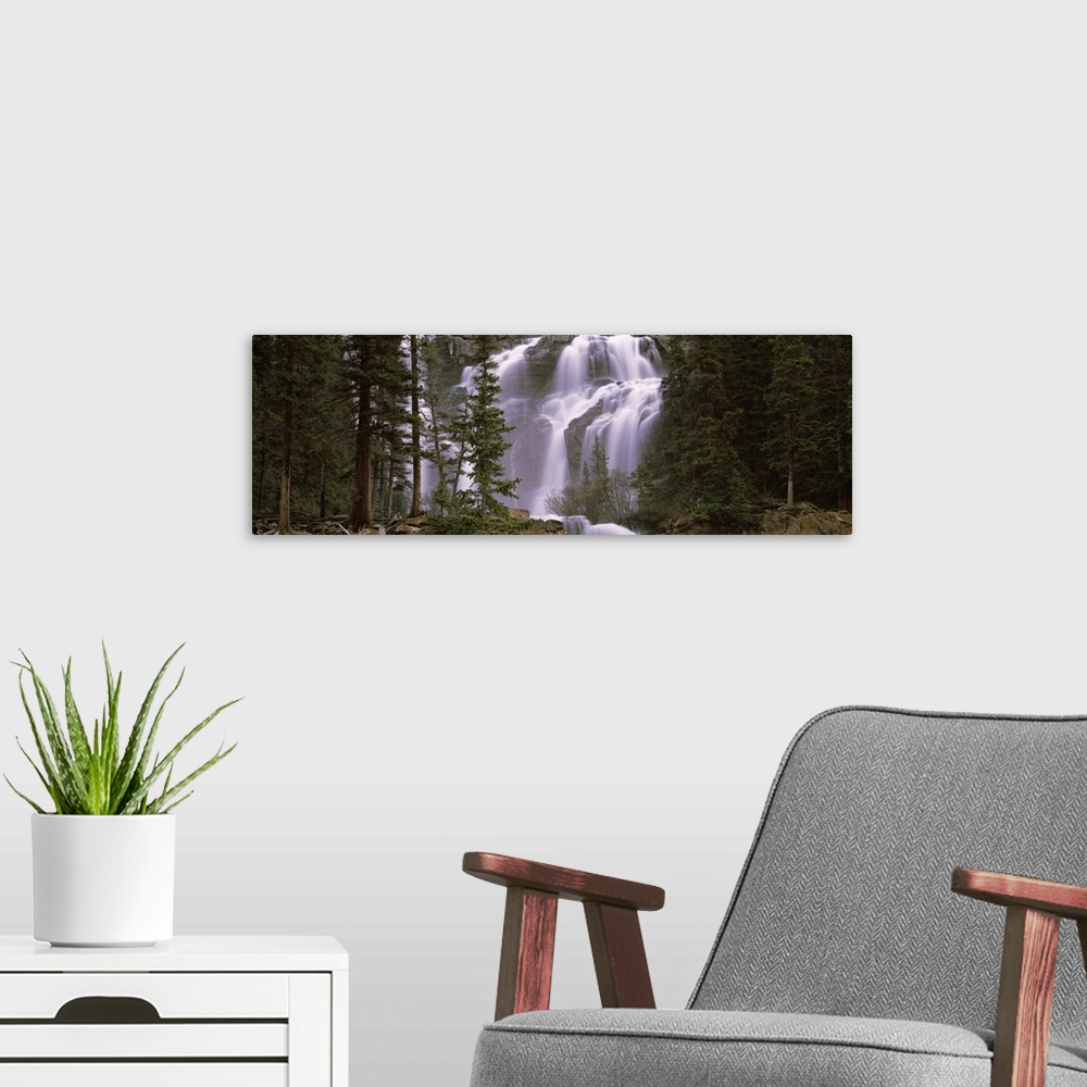 A modern room featuring Panoramic photograph shows water furiously cascading down various steep rock faces within a dense...