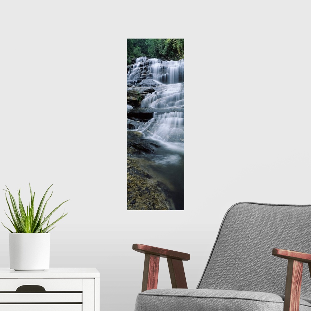 A modern room featuring Vertical panoramic of a series of smaller waterfalls making up a large stairway of water pouring ...