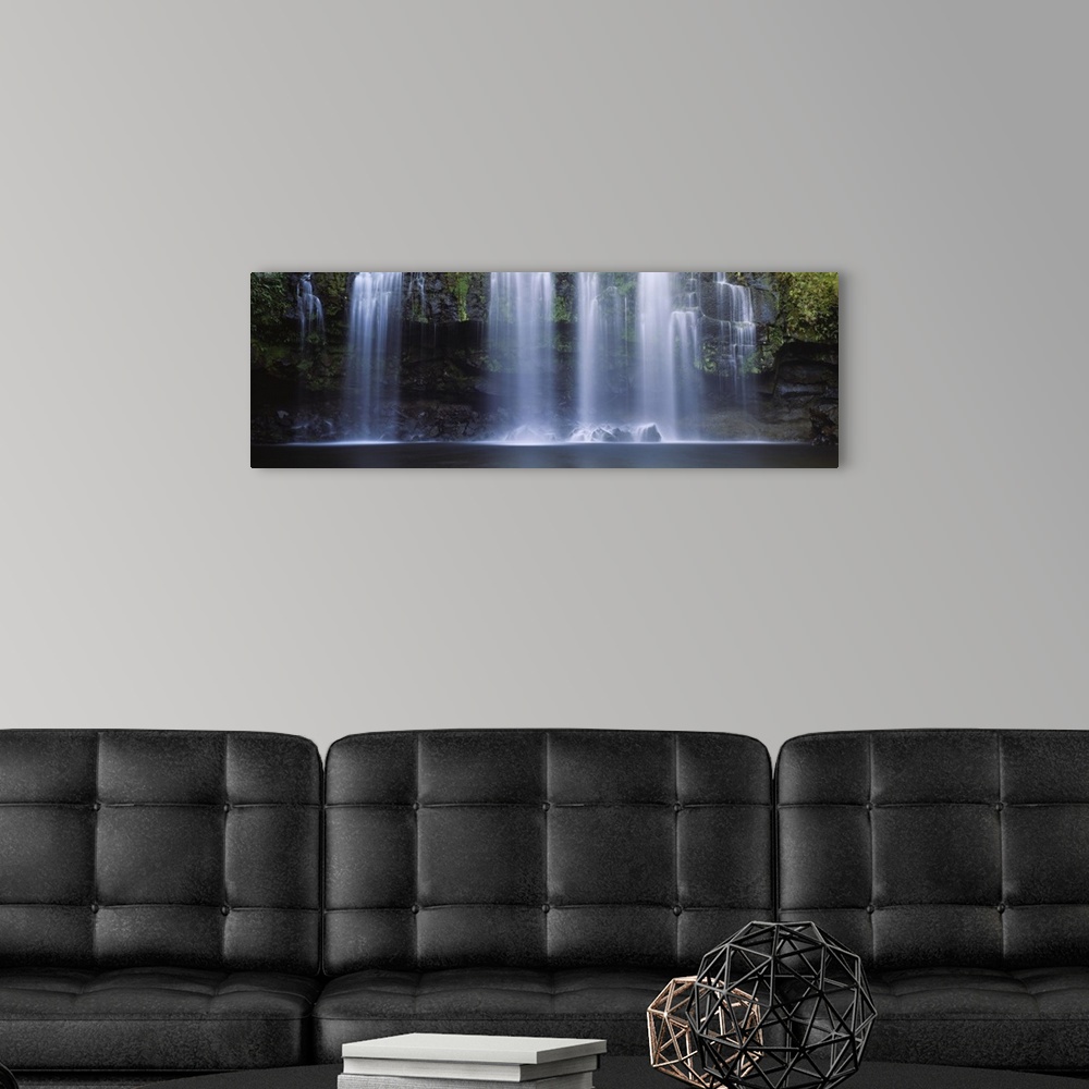 A modern room featuring Multiple cascades fall over a moss covered rock face into a pool in this panoramic photograph of ...