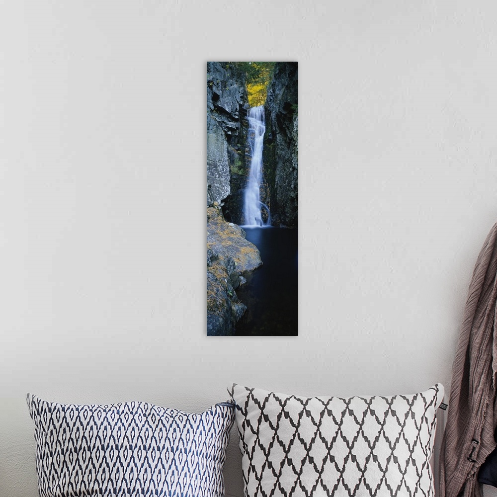 A bohemian room featuring Vertical photograph on a giant canvas of a large waterfall surrounded by the rocky edges of a for...