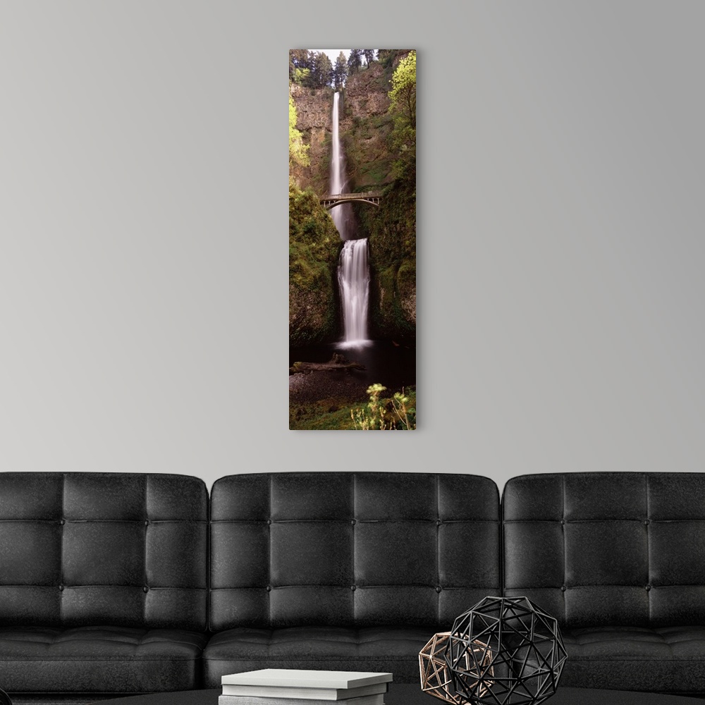 A modern room featuring Vertical panoramic photograph of water cascading over the edge of a high cliff and falling into a...