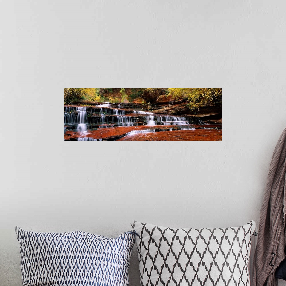 A bohemian room featuring This panoramic photograph shows water trickling down the rock steps of a canyon waterfall.