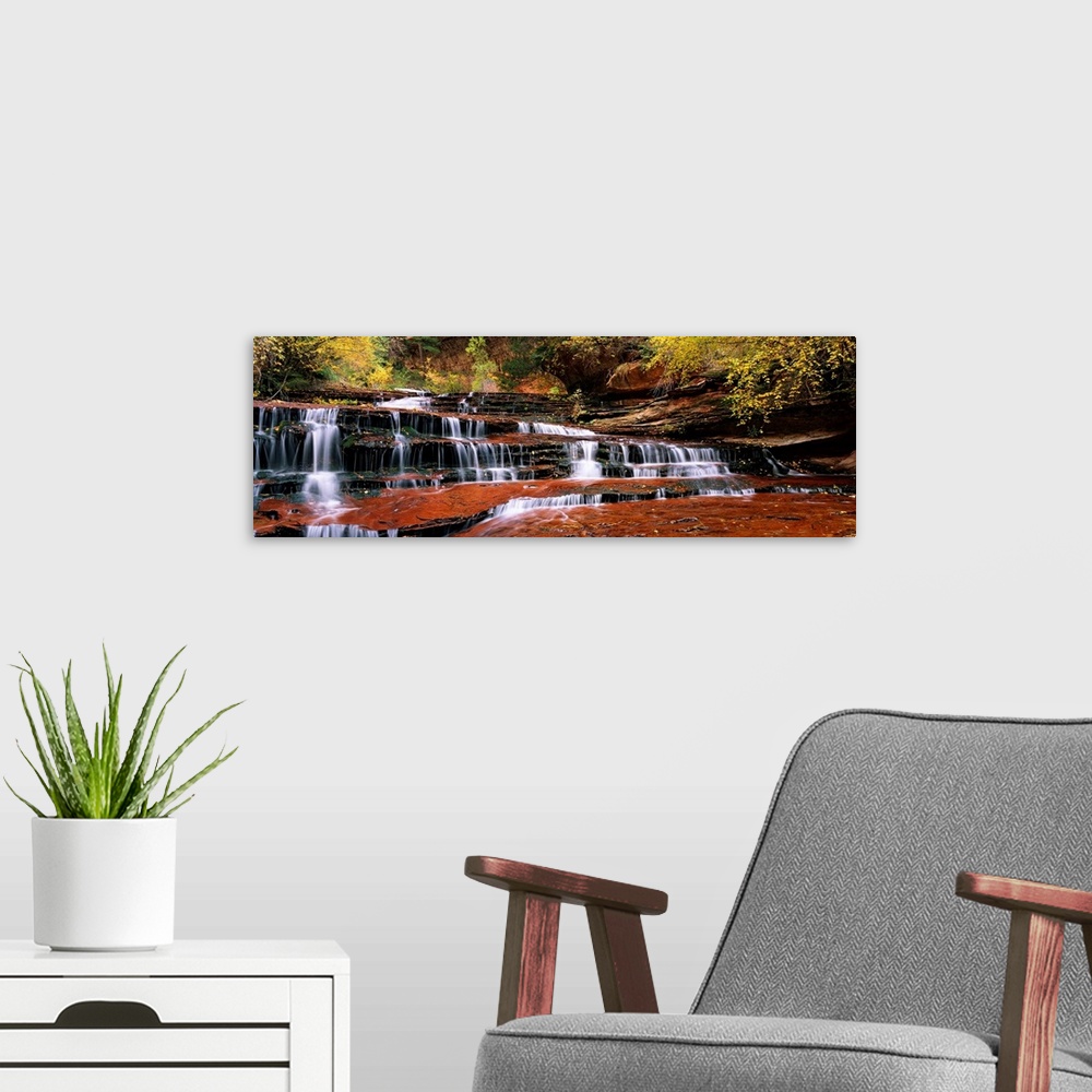 A modern room featuring This panoramic photograph shows water trickling down the rock steps of a canyon waterfall.