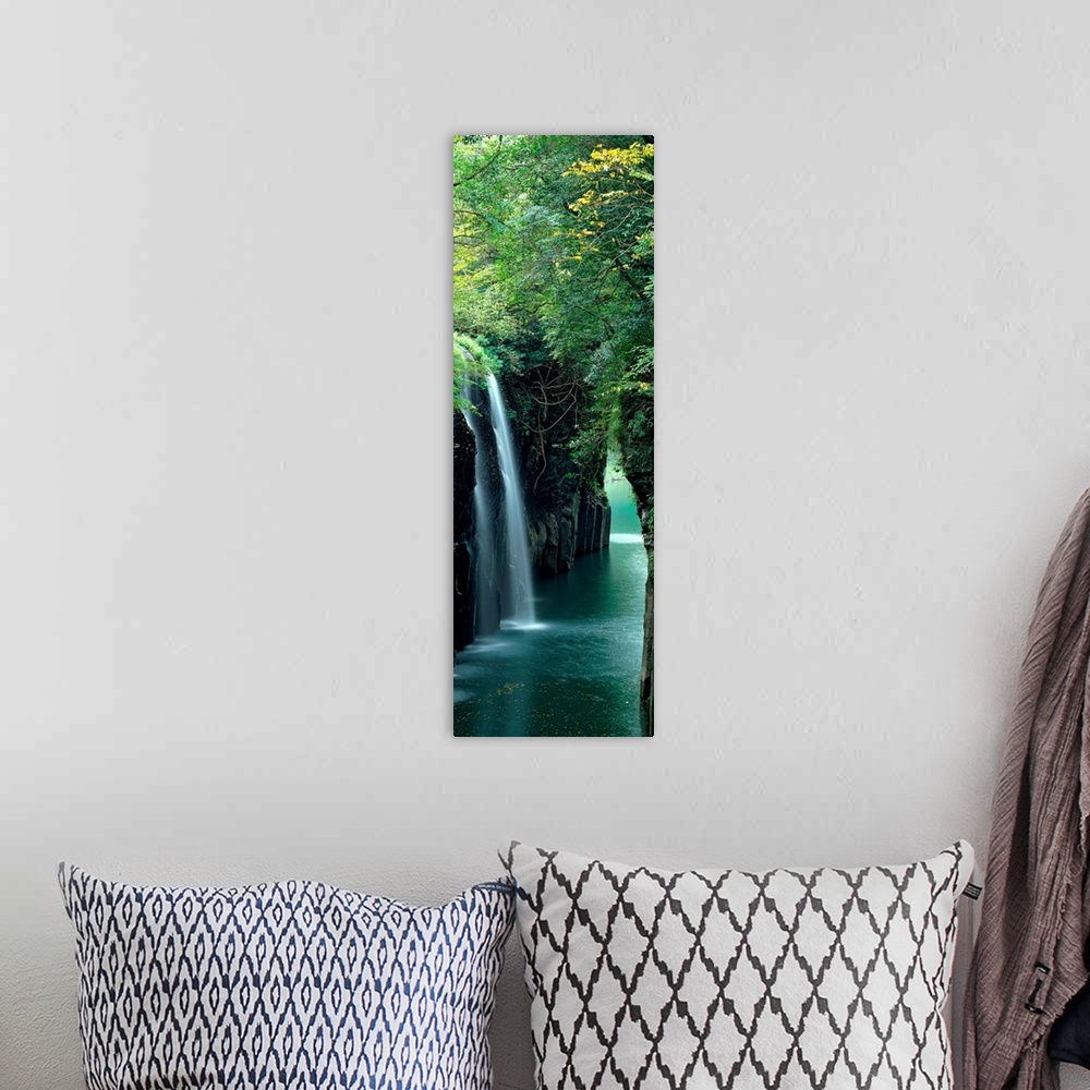 A bohemian room featuring Vertical outdoor shot of a forest, river, and waterfall taken with time-lapsed photography.