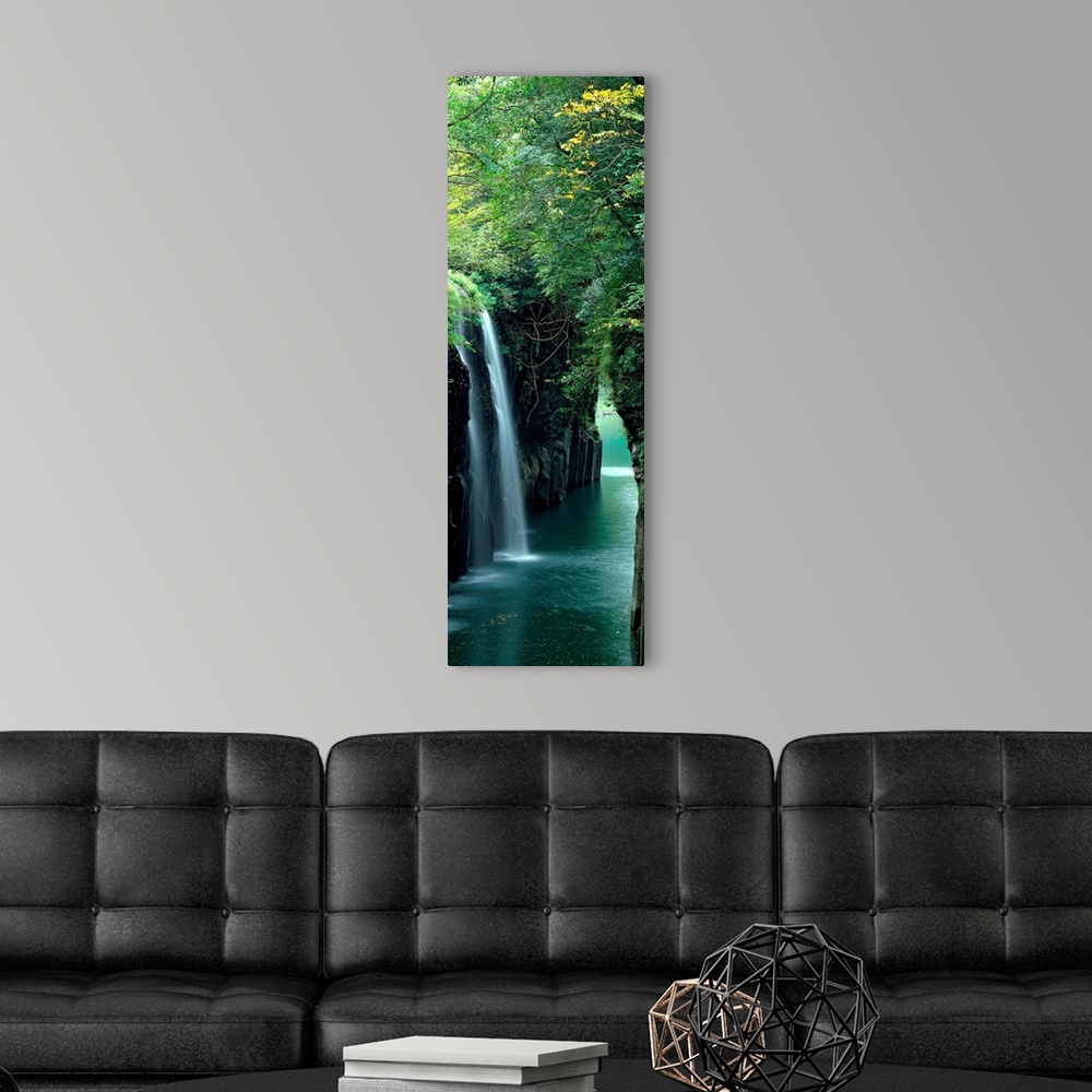 A modern room featuring Vertical outdoor shot of a forest, river, and waterfall taken with time-lapsed photography.