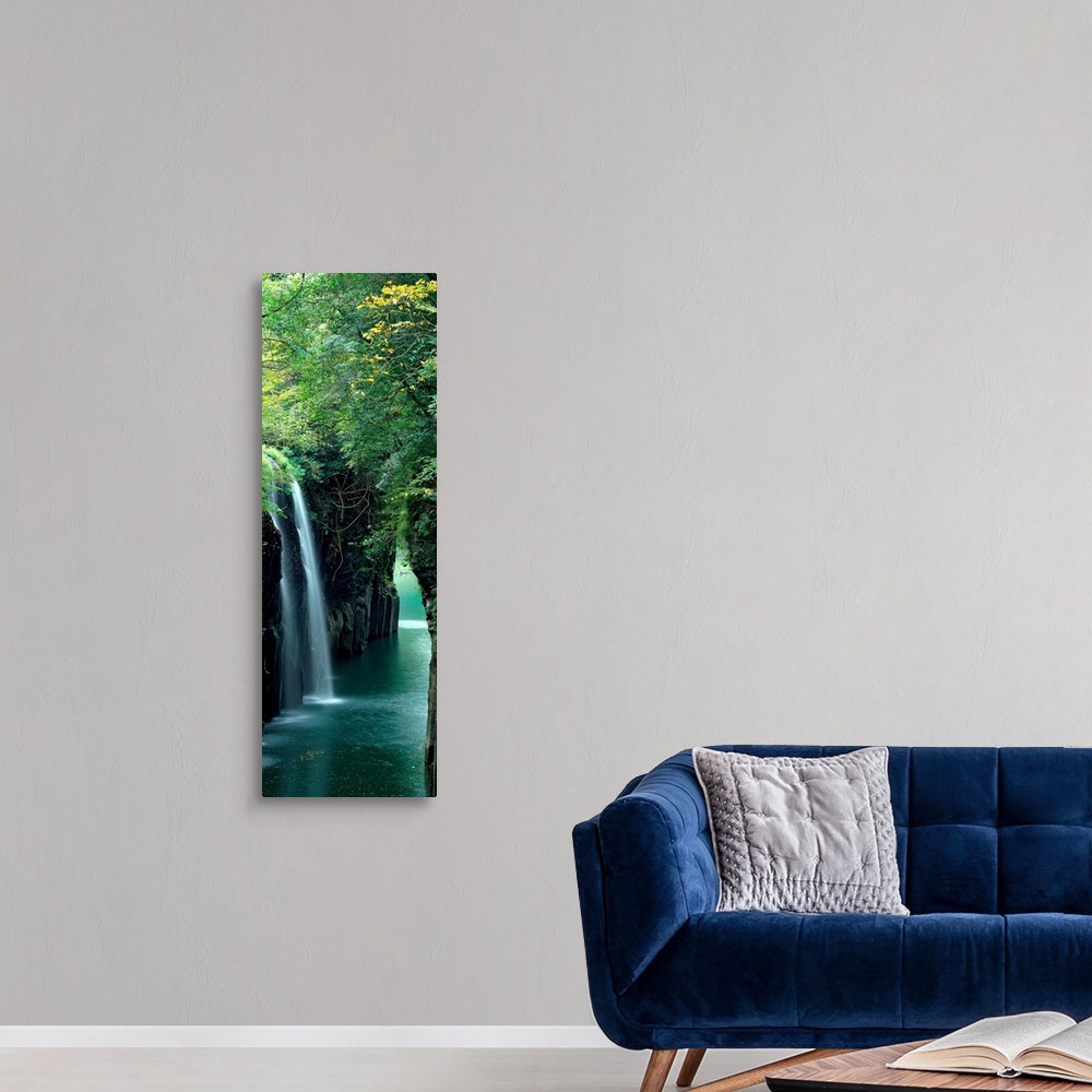 A modern room featuring Vertical outdoor shot of a forest, river, and waterfall taken with time-lapsed photography.