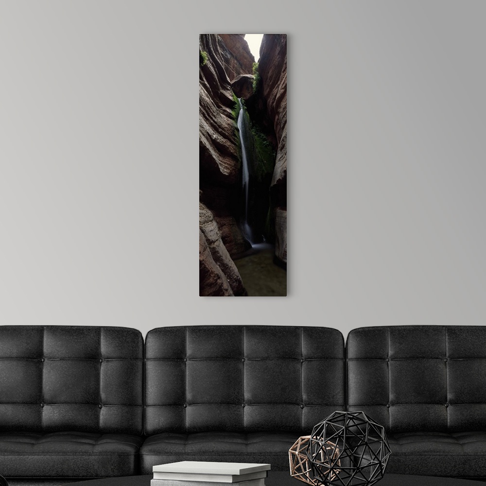 A modern room featuring Vertical panoramic photograph of cascading water falling between tall rock formations.