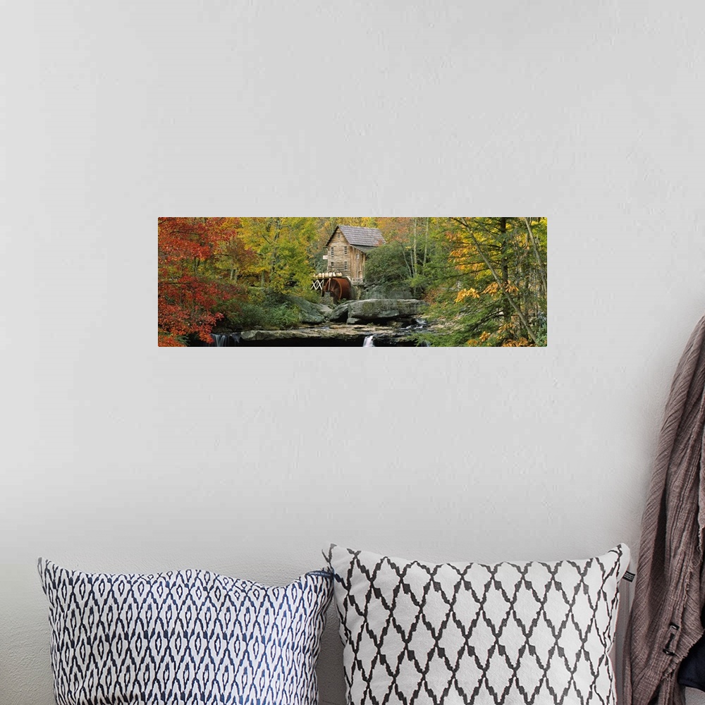 A bohemian room featuring Panoramic photograph of mill in forest surrounded by fall foliage.