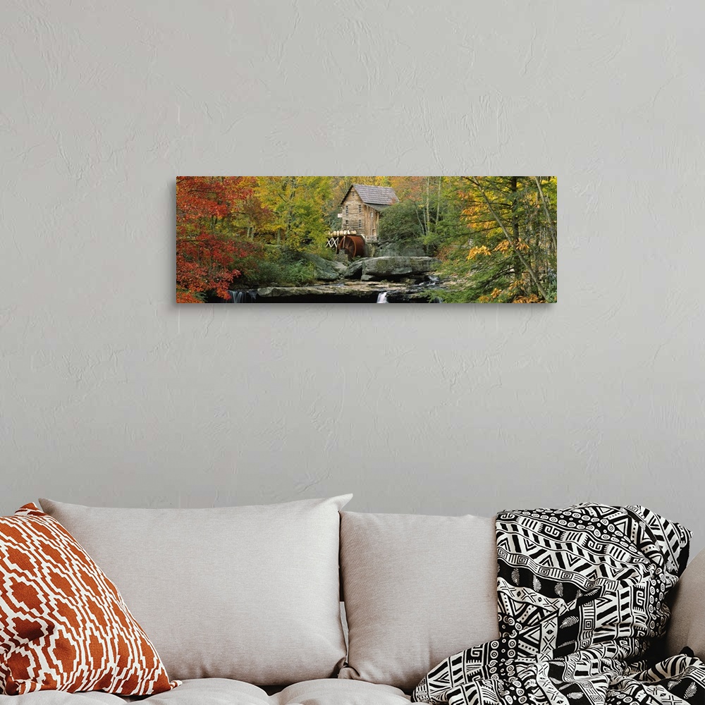A bohemian room featuring Panoramic photograph of mill in forest surrounded by fall foliage.