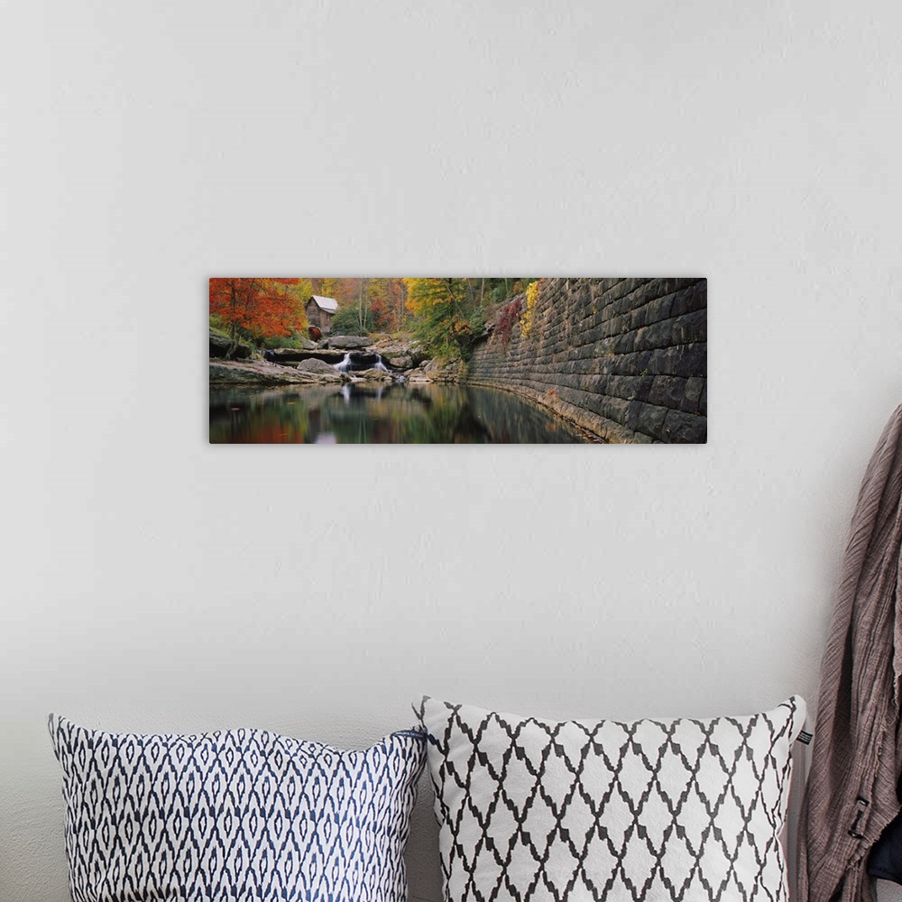 A bohemian room featuring Panoramic photo of a lake with a mill in the distance surrounded by fall foliage.