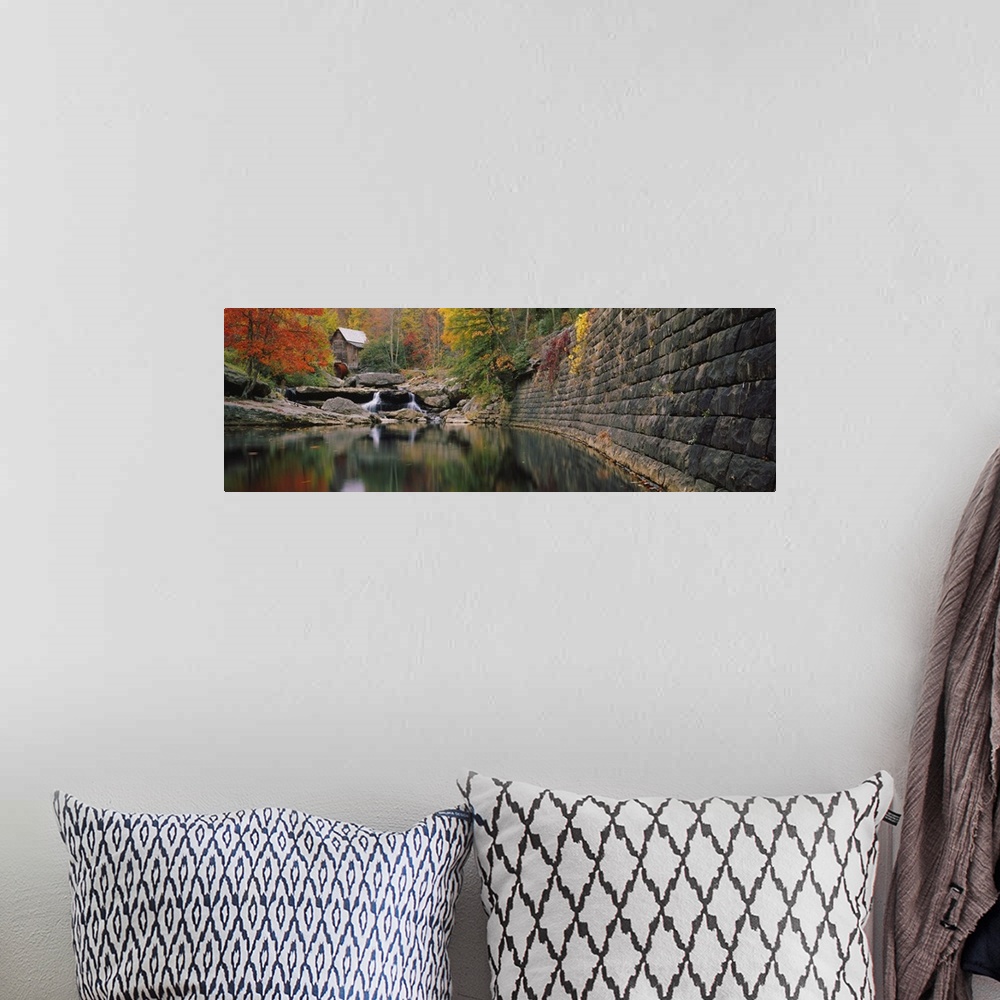 A bohemian room featuring Panoramic photo of a lake with a mill in the distance surrounded by fall foliage.