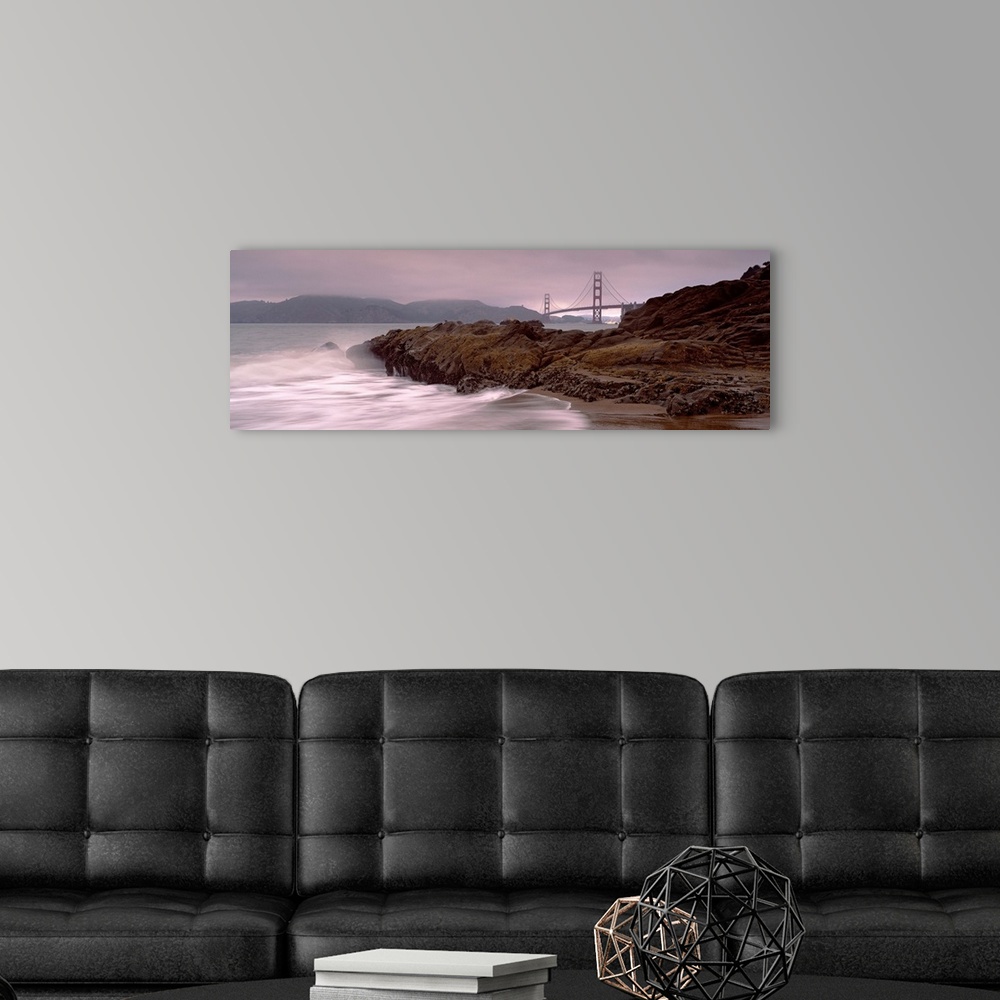 A modern room featuring Panoramic photograph shows waves breaking against the rocky shores of Baker Beach in San Francisc...