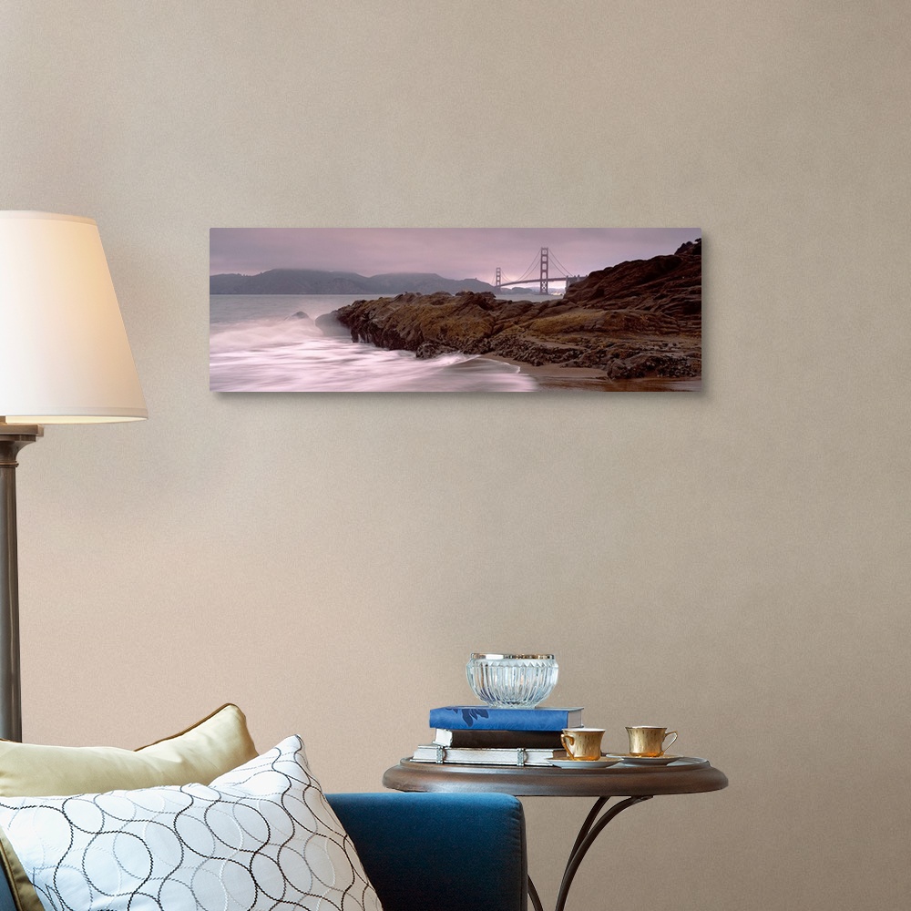 A traditional room featuring Panoramic photograph shows waves breaking against the rocky shores of Baker Beach in San Francisc...