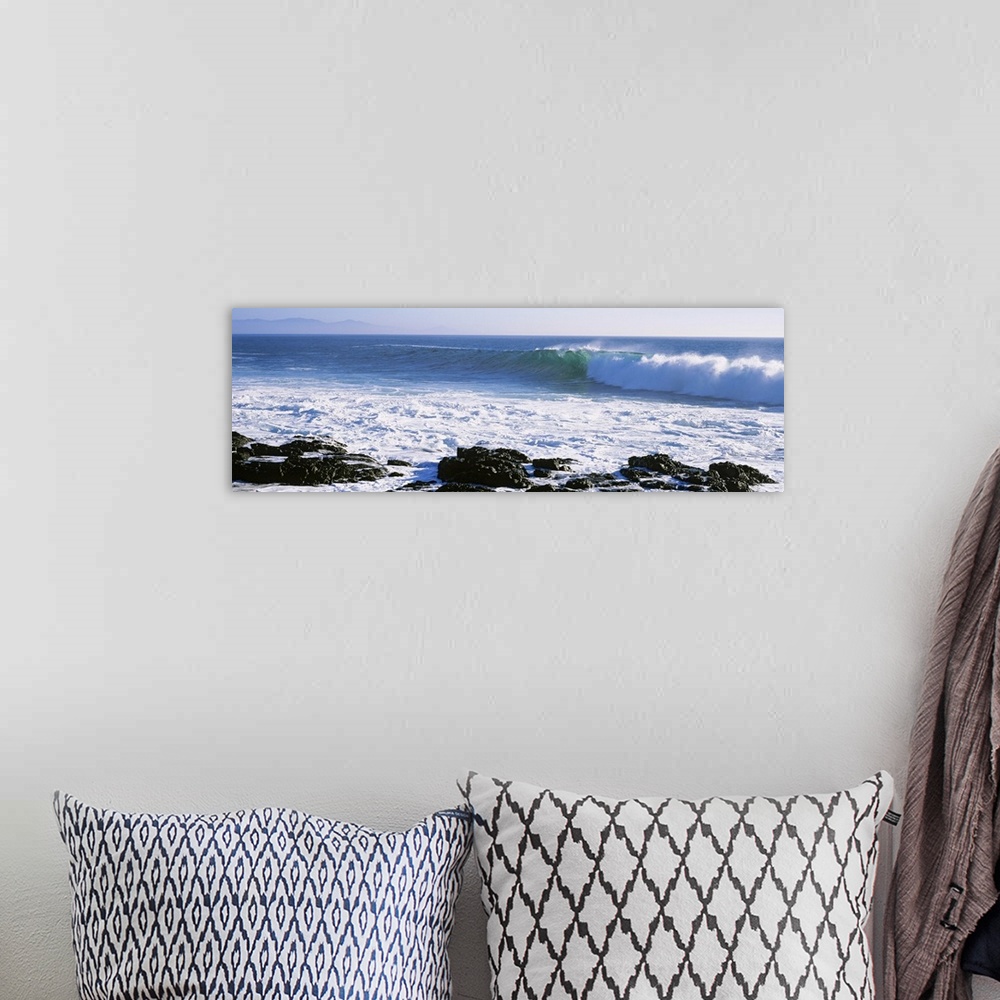 A bohemian room featuring Long image on canvas of big waves crashing onto a rocky shore.