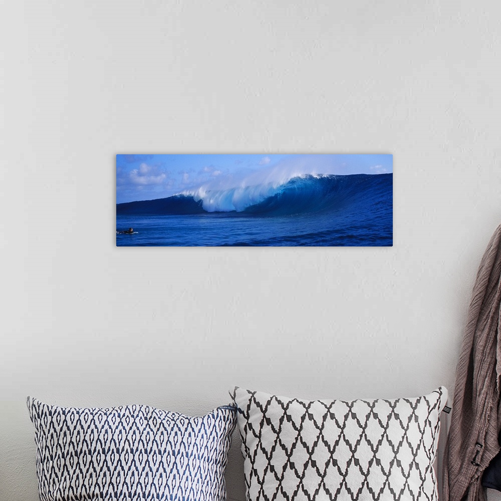 A bohemian room featuring This panoramic photograph captures a curling wave collapses on itself while a surfer paddles out ...