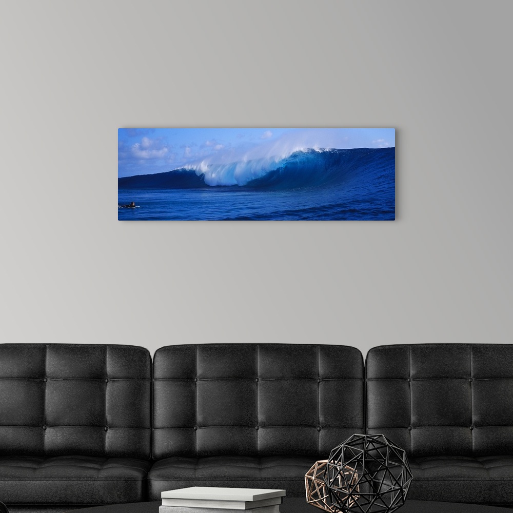 A modern room featuring This panoramic photograph captures a curling wave collapses on itself while a surfer paddles out ...