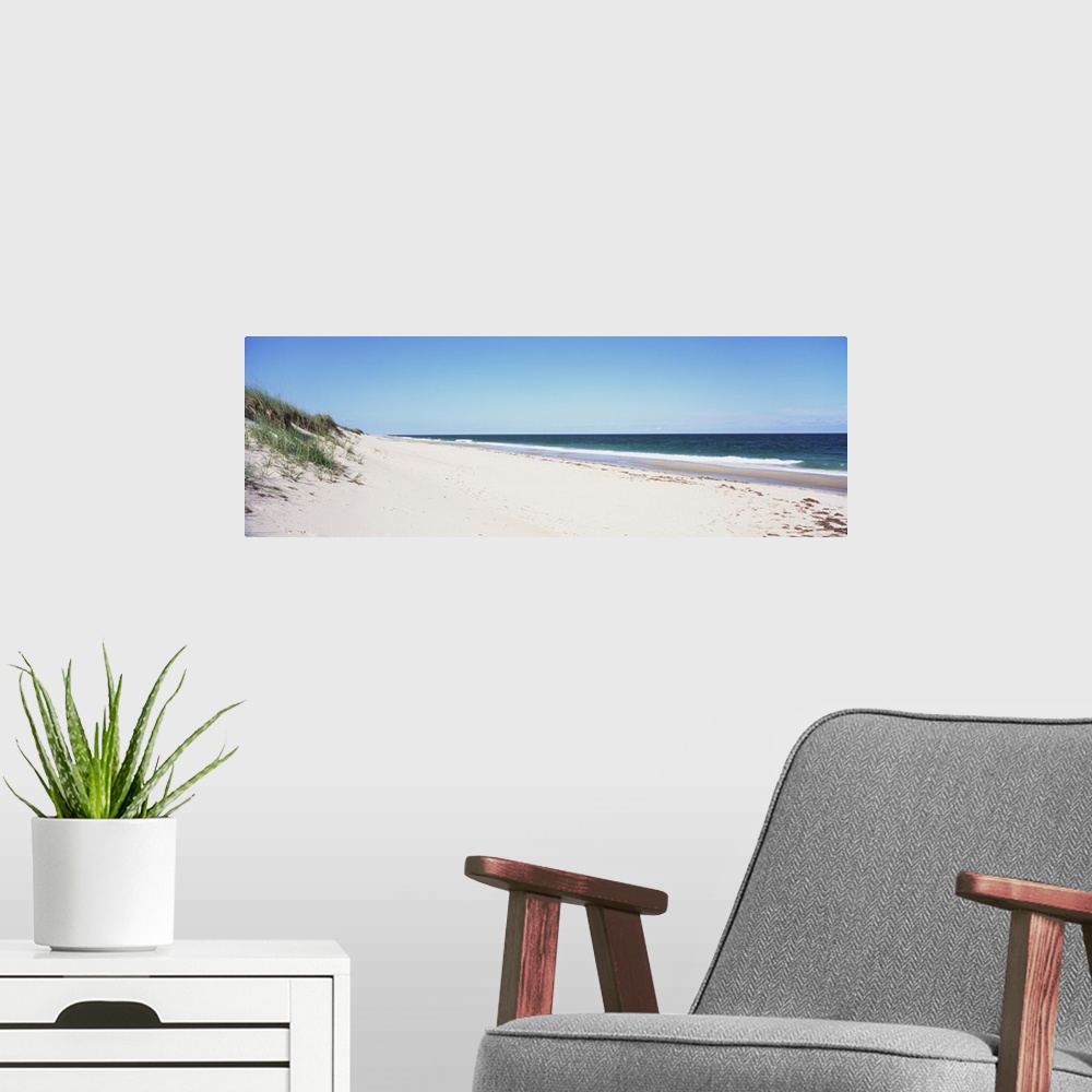 A modern room featuring Panoramic photograph taken of the beach with the sand dunes just to the left and the ocean water ...