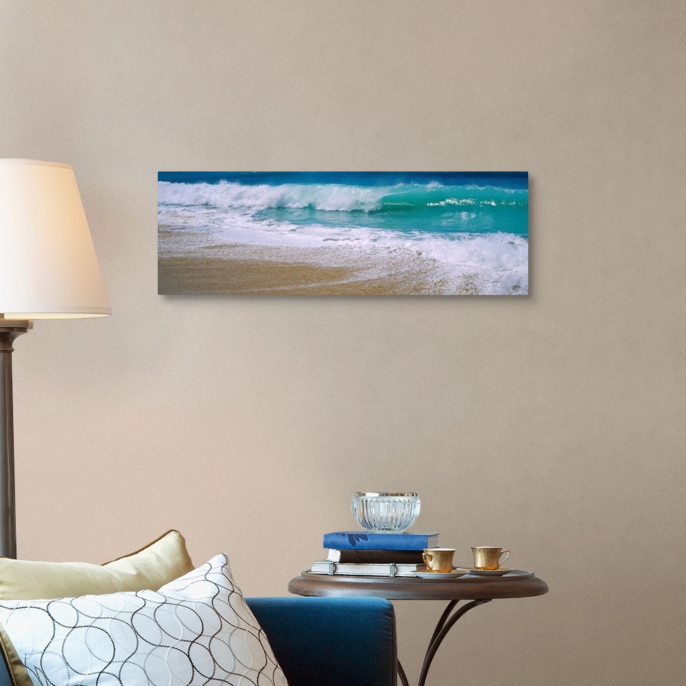 A traditional room featuring Panoramic photograph of water crashing onto the sand and being swept back out to sea.
